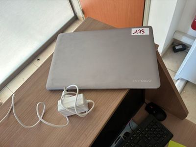 un ordinateur portable posé sur un bureau, à côté d'un clavier et d'une souris