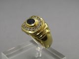 a close up of a gold ring with a sapphire and diamonds