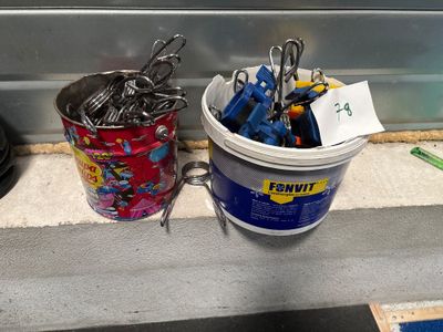 un seau rempli de ciseaux à côté d'un seau rempli de crayons, posés sur un comptoir