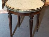 a small table with a marble top in front of a fireplace
