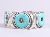 un gros plan d'une bague ornée de deux yeux en turquoise