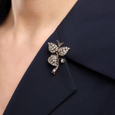 a close up of a person wearing a suit and a broochet
