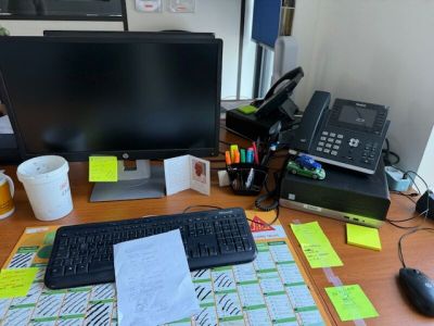 un bureau sur lequel se trouvent un ordinateur, un clavier, une souris et des papiers