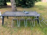 a table with chairs and a grill in the grass