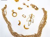 a lot of gold jewelry on a white surface