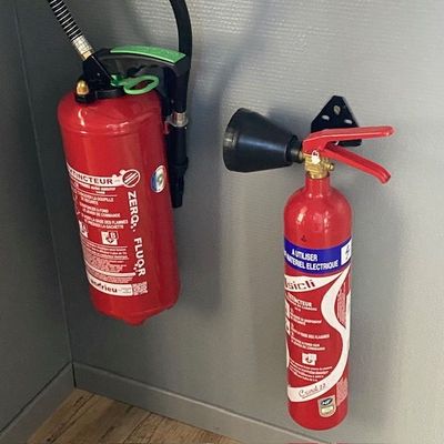 deux extincteurs accrochés au mur l'un à côté de l'autre