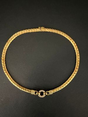un collier en or posé sur une surface noire