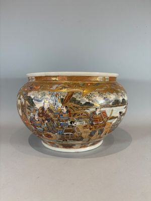 a vase with a painting on it sitting on a table