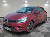 une voiture rouge est garée dans une pièce au sol en damier