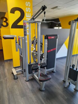 une salle de sport équipée de deux appareils et d'un mur jaune