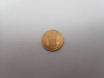 gros plan d'une pièce d'or sur une surface blanche