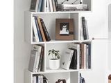 une étagère blanche sur laquelle sont posés de nombreux livres