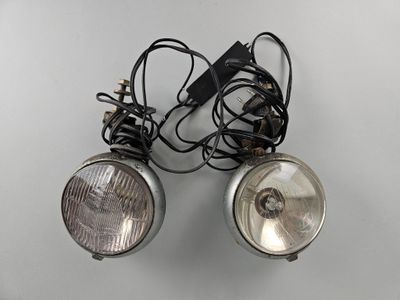 pair of vintage motorcycle headlight lamps with cord and plugged wires