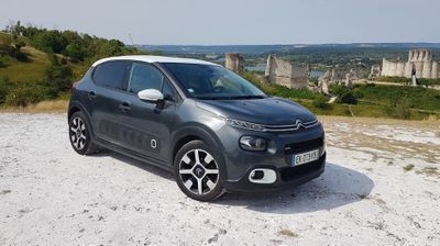 the small car is parked on the side of the road