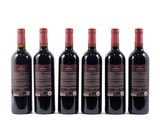 four bottles of red wine are lined up on a white surface