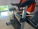 a gym room with a tread machine and a window