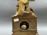 a gold clock with a statue on top of it