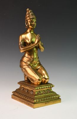 statue en bronze représentant une femme assise sur un socle, les mains croisées