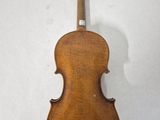 an old violin sitting on top of a white surface
