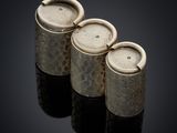 three silver vases sitting on top of a black surface