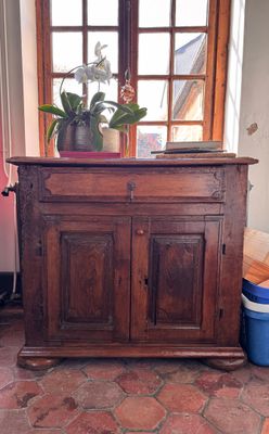 a wooden cabinet with a potted plant on top of it