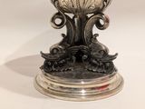 a silver vase that is sitting on top of a table