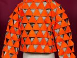 an orange jacket with black and white triangles on it on a mannequin