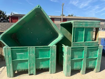 three green bins sitting next to each other on the ground