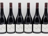 six bottles of red wine are lined up in a row