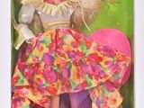 La poupée Barbie se trouve dans la boîte, vêtue d'une robe rose.
