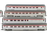 several model trains are lined up in a row on a white surface