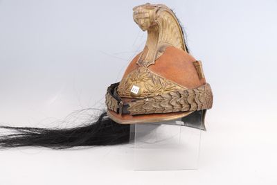 un casque surmonté d'un cheval, posé sur un socle