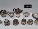 a lot of silver teapots and cups on a table