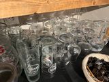 bottles and glasses on a table with a bowl of chocolates