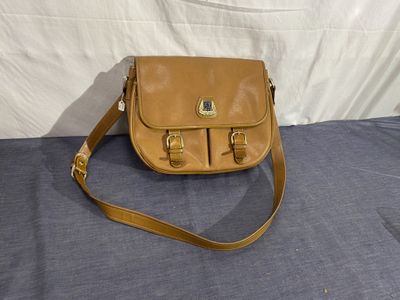 sac à main Coach en cuir marron clair, avec finitions en laiton et bandoulière