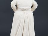 a white statue of a woman with her hands on her hips