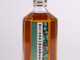 a close up of a bottle of liquor on a white surface