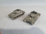 two toy tanks sitting next to each other on a table