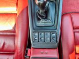 une photo du tableau de bord d'une voiture avec une statuette représentant un homme posée sur la console centrale