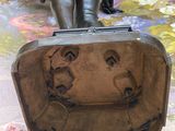 a statue of a woman sitting on top of a suitcase