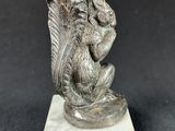 an image of a statue of a bird sitting on top of a marble block