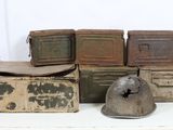 many old boxes and a helmet on a white table