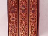 trois livres rouges superposés sur une surface blanche