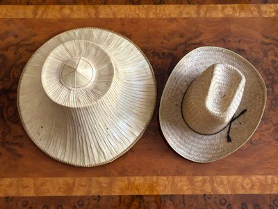 two hats that are sitting on top of a wooden table