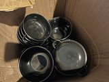 several pots and pans are in a cardboard box on the floor