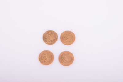 un gros plan sur quatre pièces de un penny posées sur une surface blanche