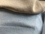 the back of a person ' s sweater with a small white logo on it