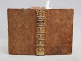 un vieux livre à la couverture marron et à la reliure dorée