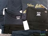 a lot of t - shirts that are sitting on a table