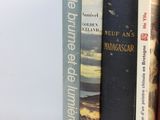 several books are stacked on top of each other on a white surface